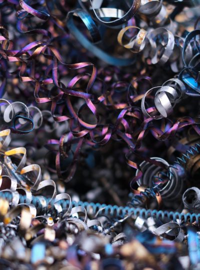 Twisted metal spirals pile up in a chaotic heap, showcasing the byproducts of machine manufacturing