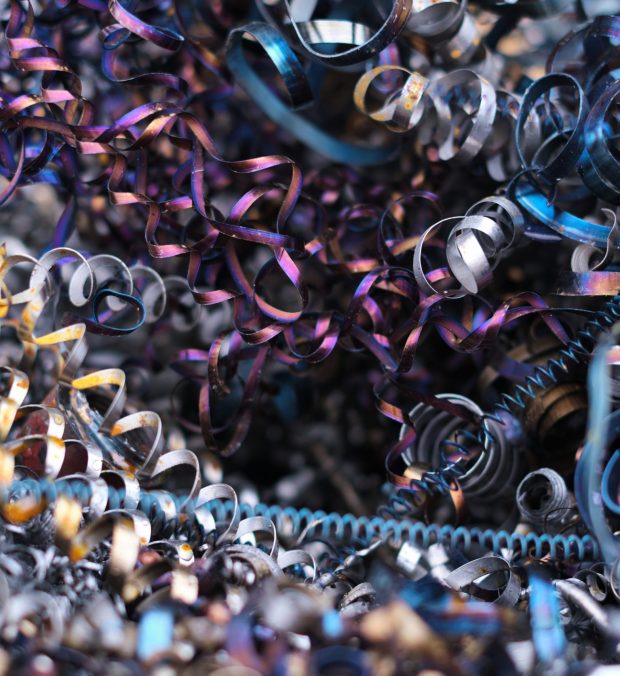 Twisted metal spirals pile up in a chaotic heap, showcasing the byproducts of machine manufacturing